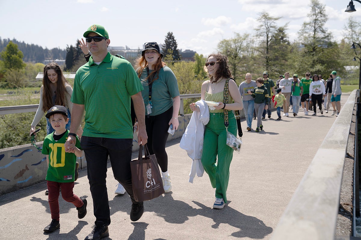 Families walk across the footbridge to Autzen Stadium