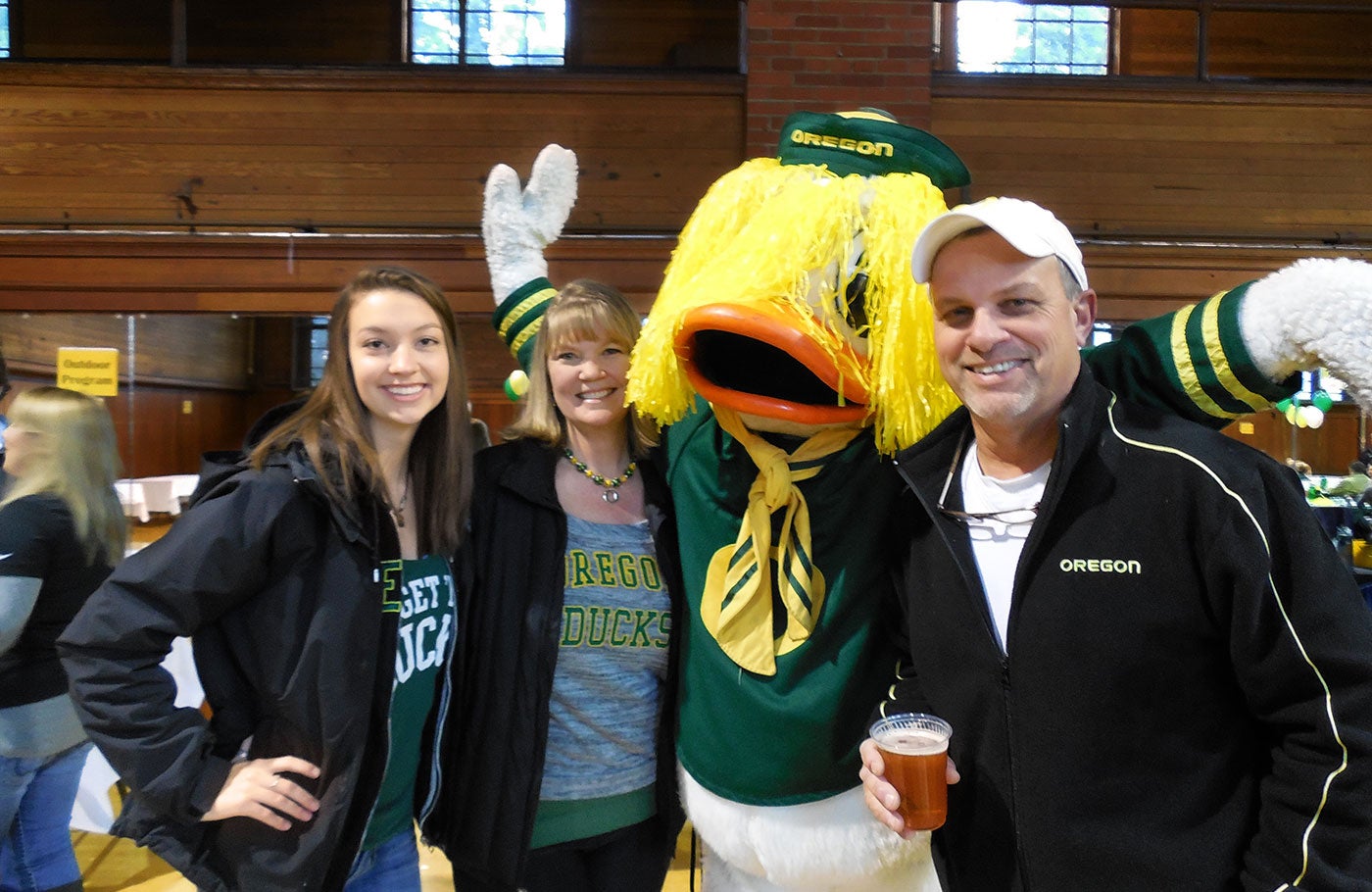 Family posing with the Duck at a reception in Gerlinger Hall.
